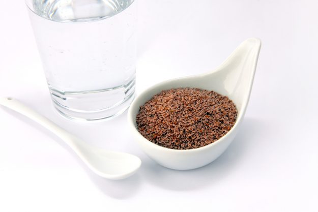 Flohsamen in Schale mit Wasserglas